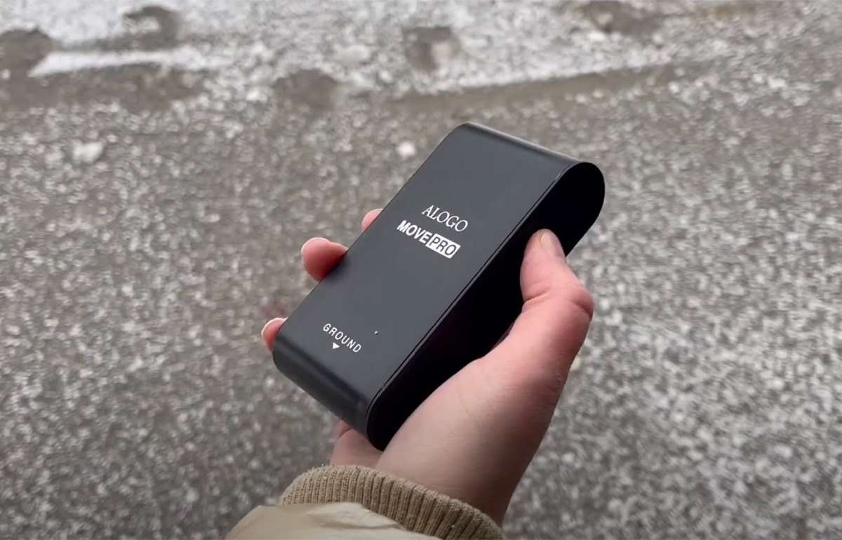 Alogo Move Pro held in a hand, top face up to the clear sky, waiting for the GPS signal