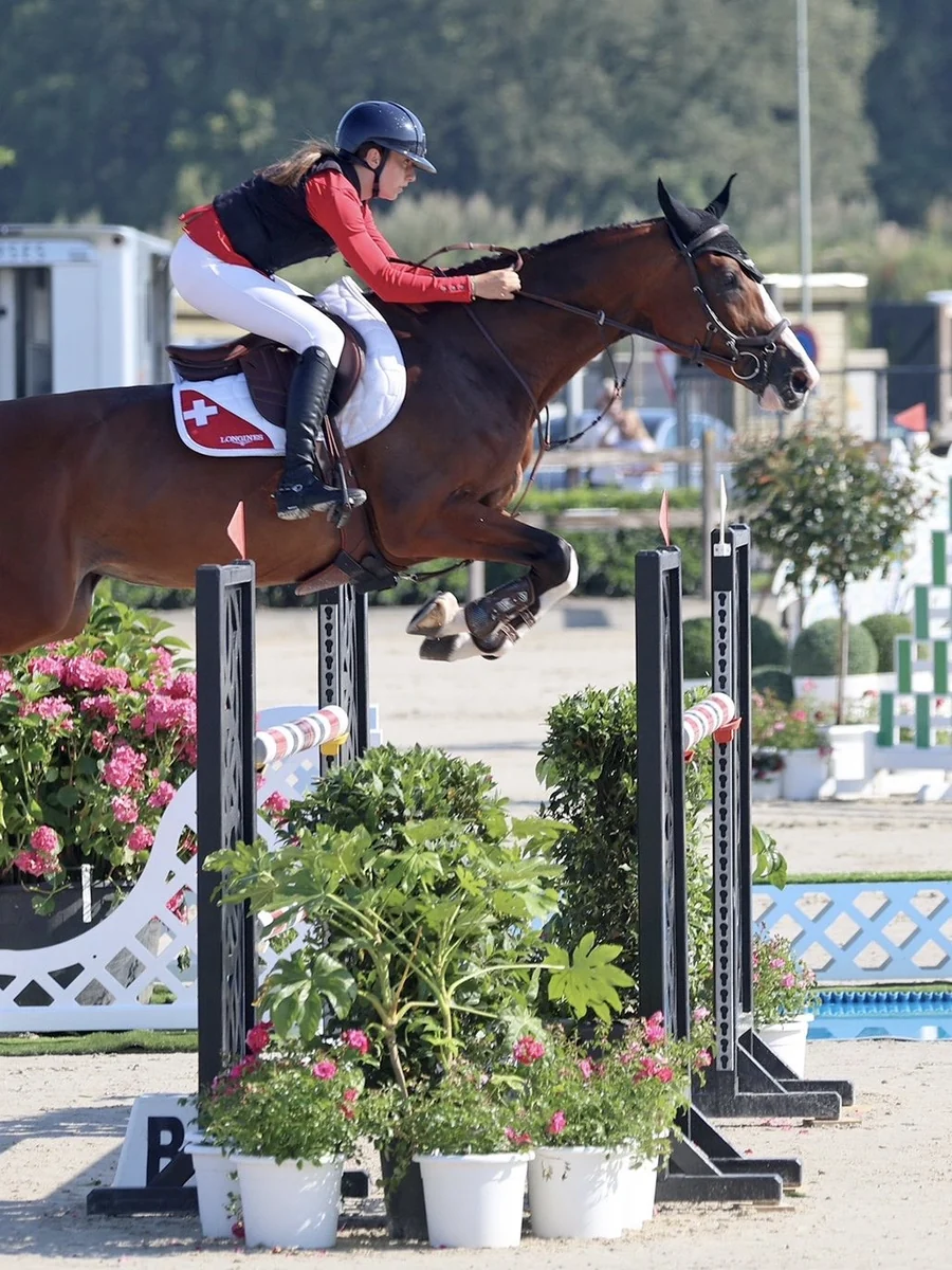 Léonie Alessandra Pelloni, ambassadrice Alogo, en concours de saut d'obstacles avec le tapis de l'équipe de Suisse.
